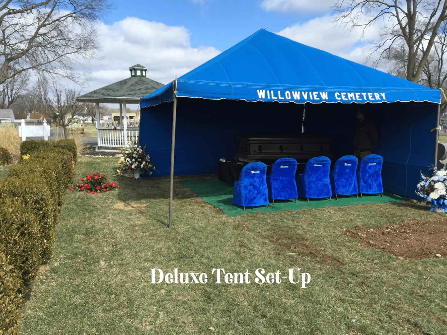 A blue tent set up in the grass.